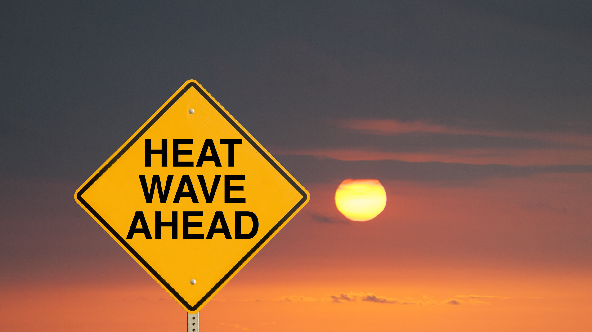 Heatwave warning sign at sunset