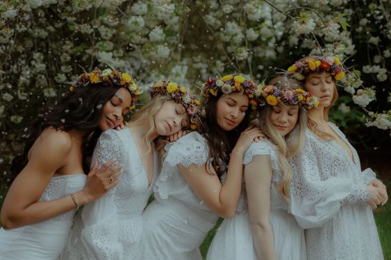 Photo of a group of girls hugging eachtoher, each adorned with flower crowns and bright smiles