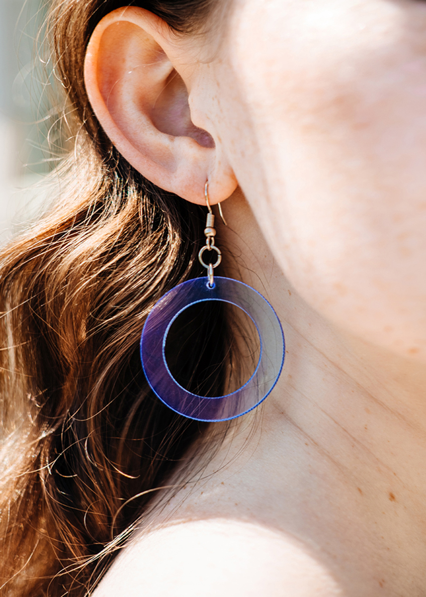 large blue circle cutout earrrings worn