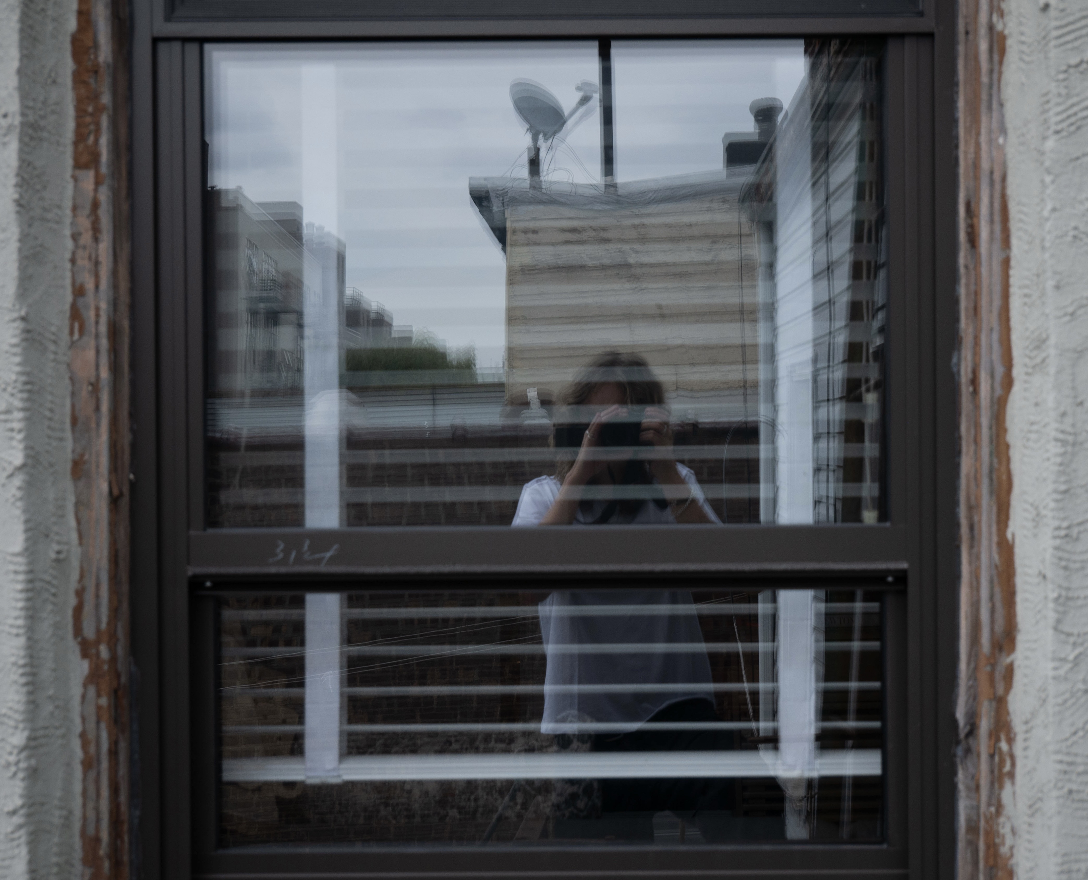 Amelie taking a reflective photo off window