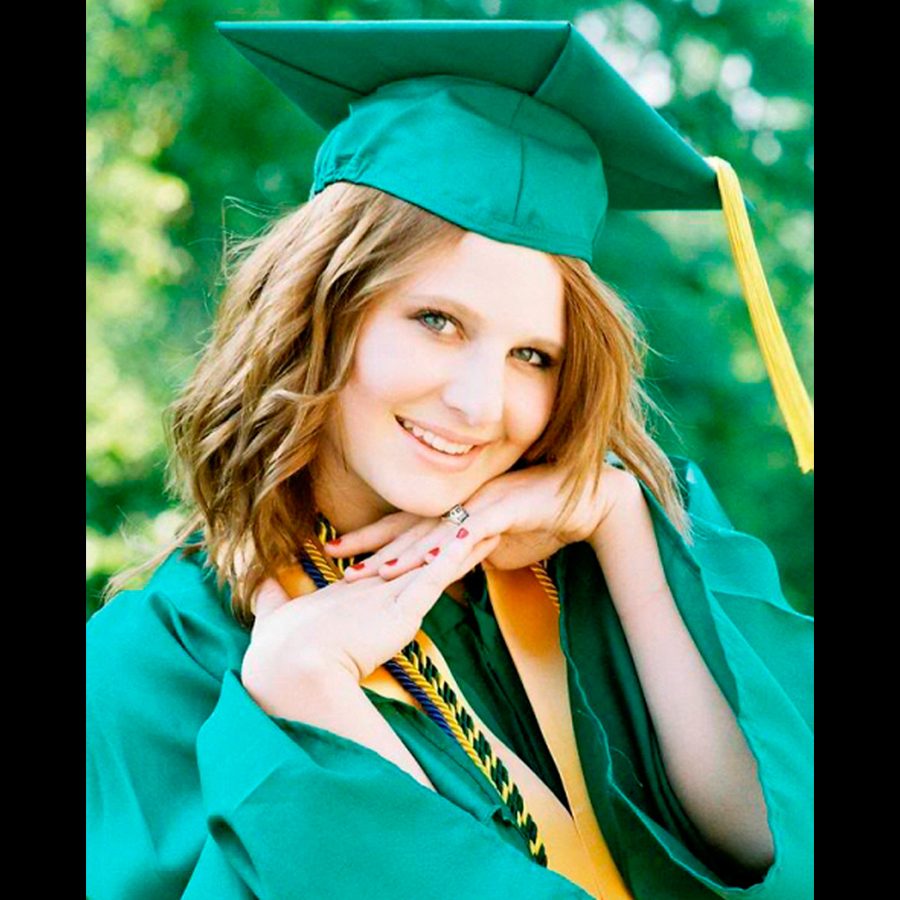 Close up of  high school girl in a green cap and gown.
