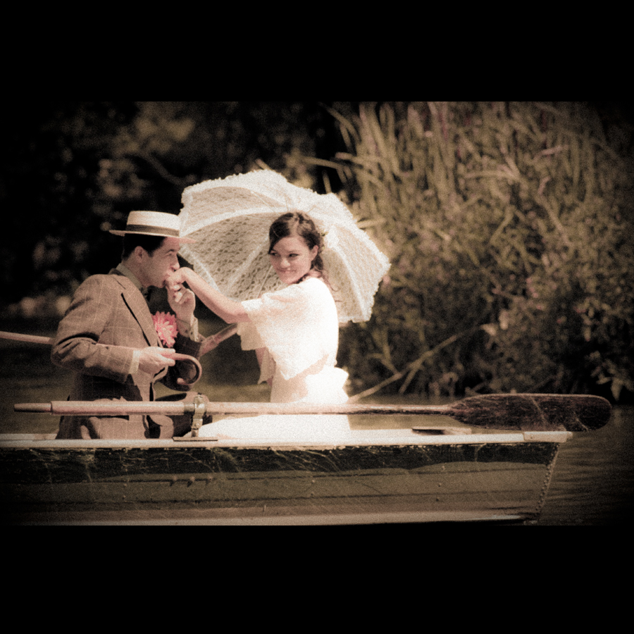 Groom kisses the bride's hand while they float in a rowboat
