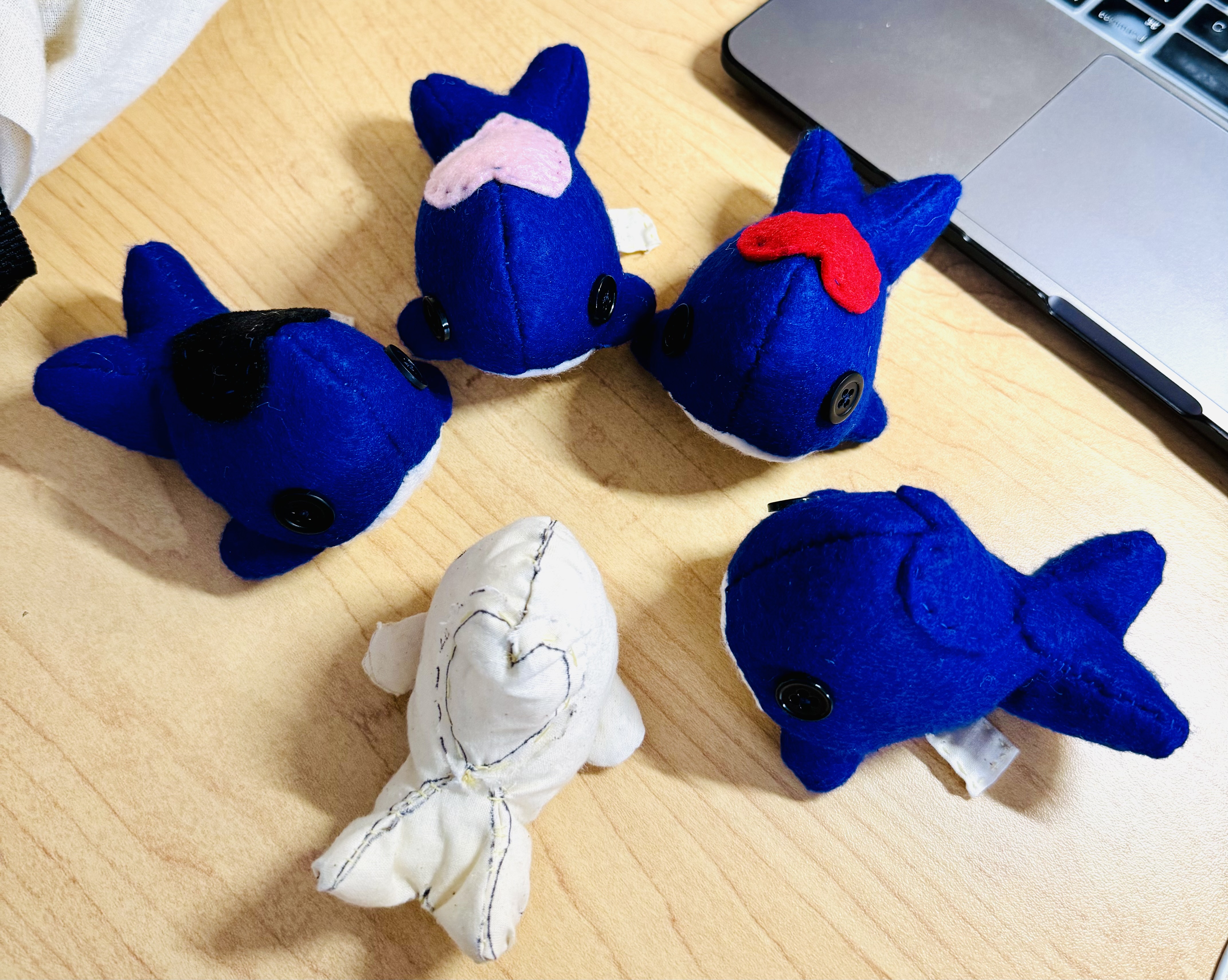 A half circle of whales around a prototype whale